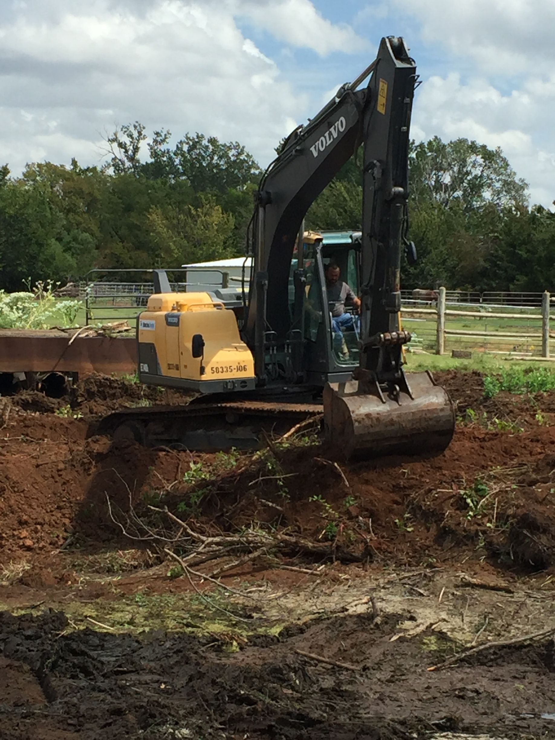 A volvo excavator is digging a hole in the dirt.