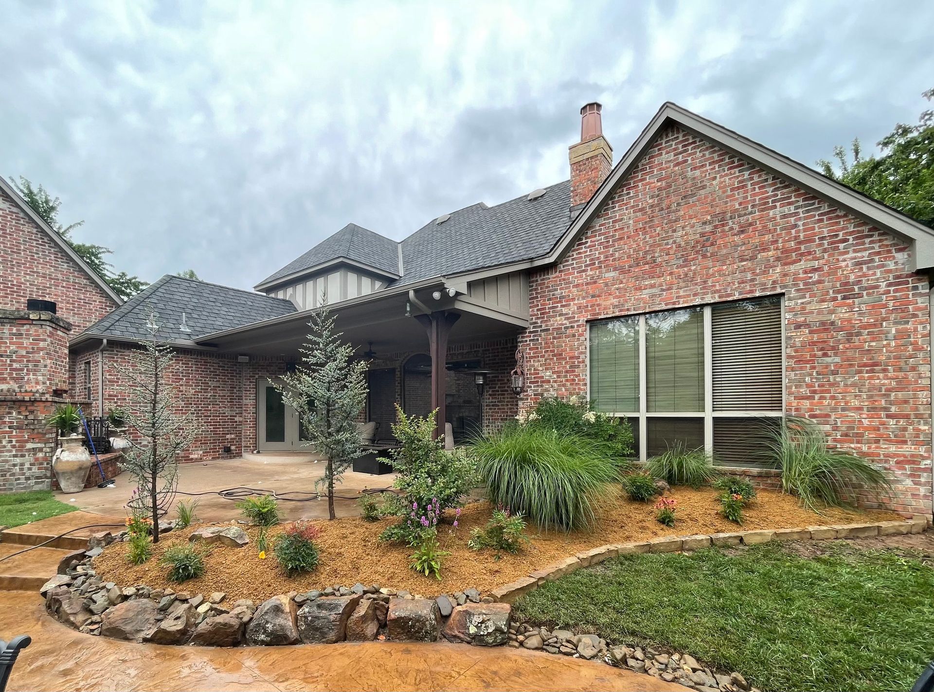 A large brick house with a patio and a covered porch.
