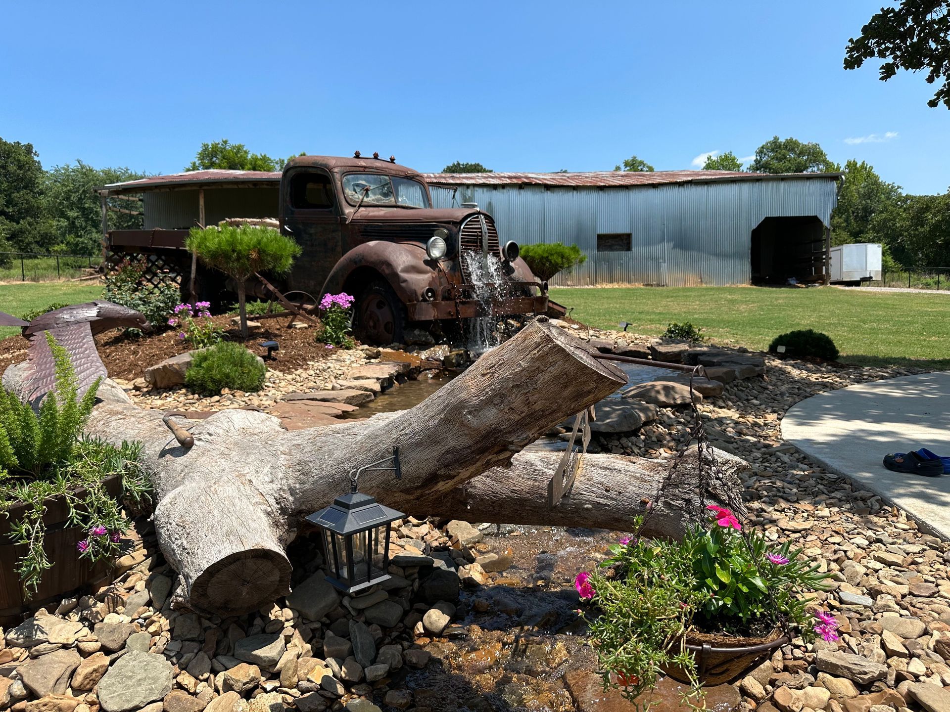 An old rusty truck is parked in front of a barn.