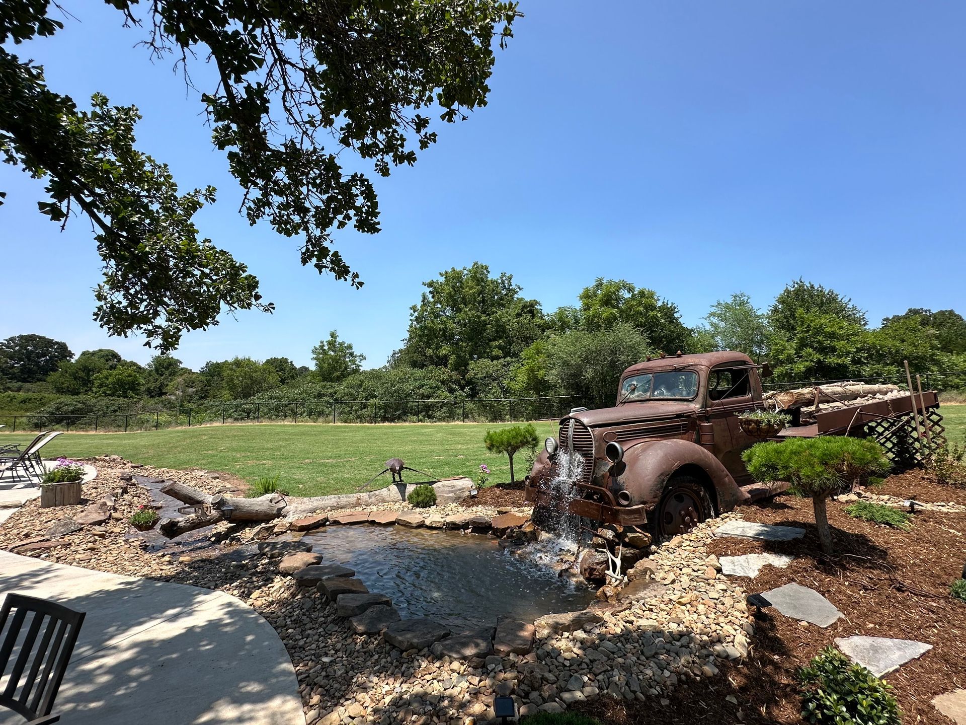 An old rusty truck is parked next to a waterfall