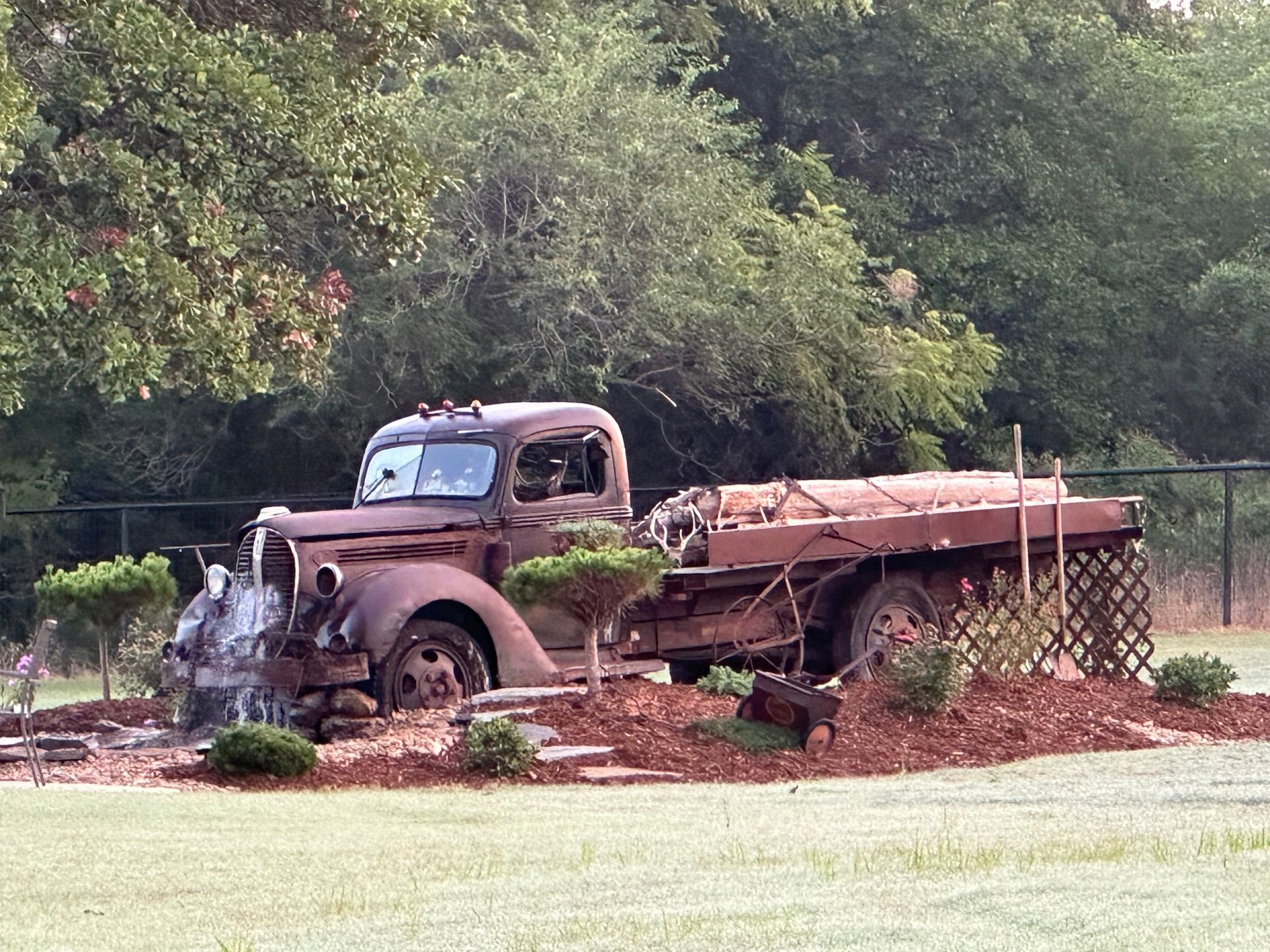 An old rusty truck is parked in a grassy field