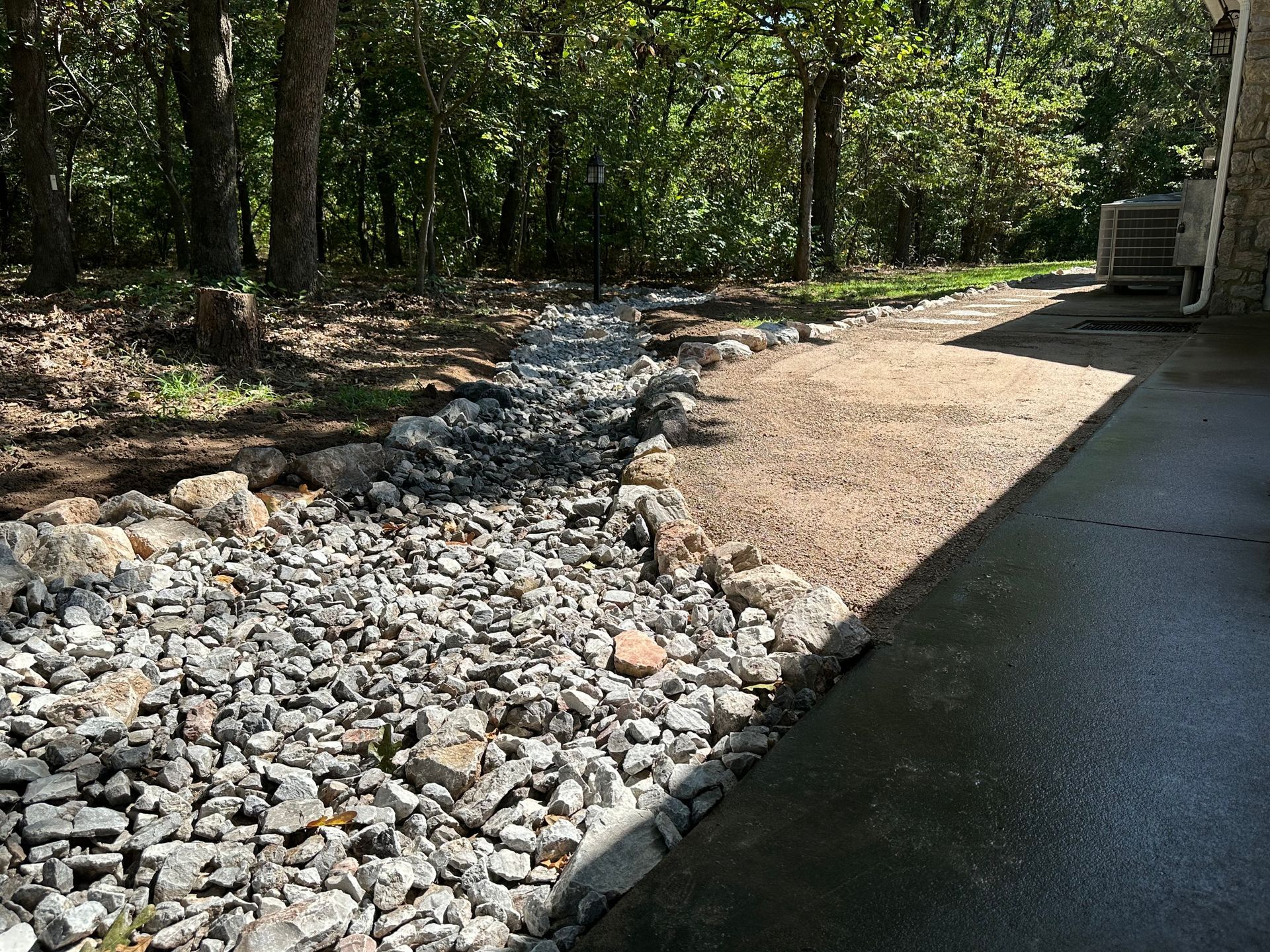 A truck is parked in a driveway next to a pile of rocks.