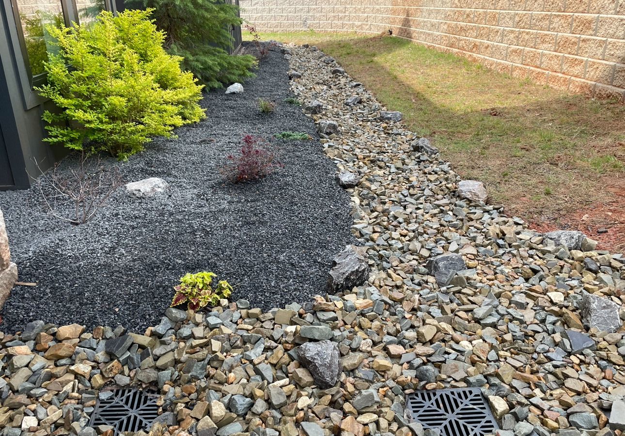 A gravel path with a drain in the middle of it.