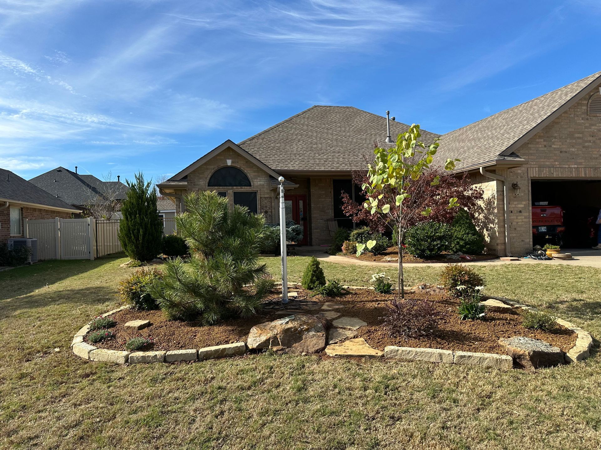 A house with a garden in front of it and a garage.