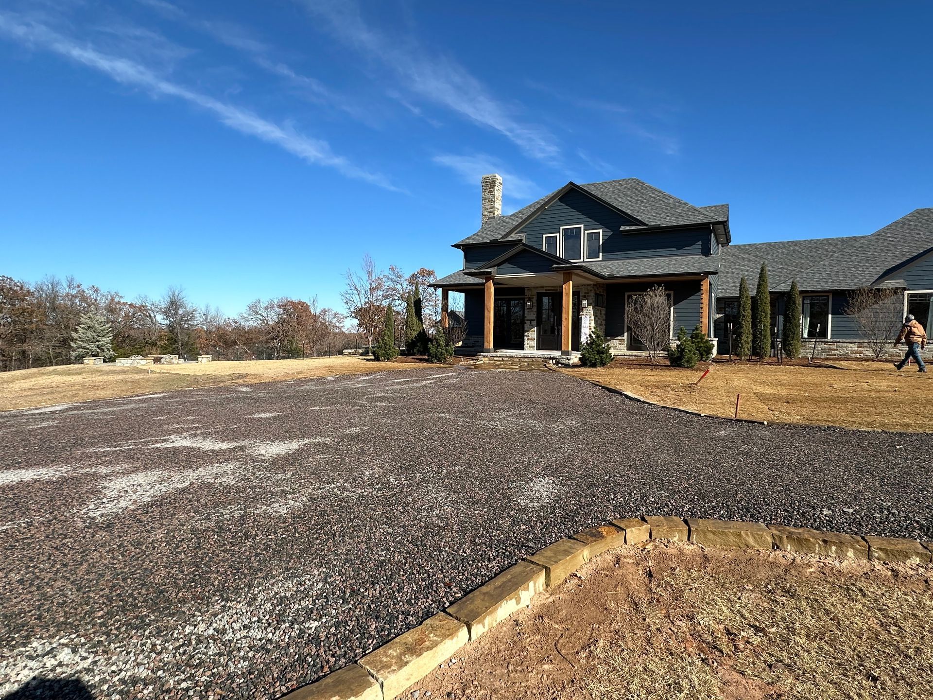 A large house with a gravel driveway in front of it.