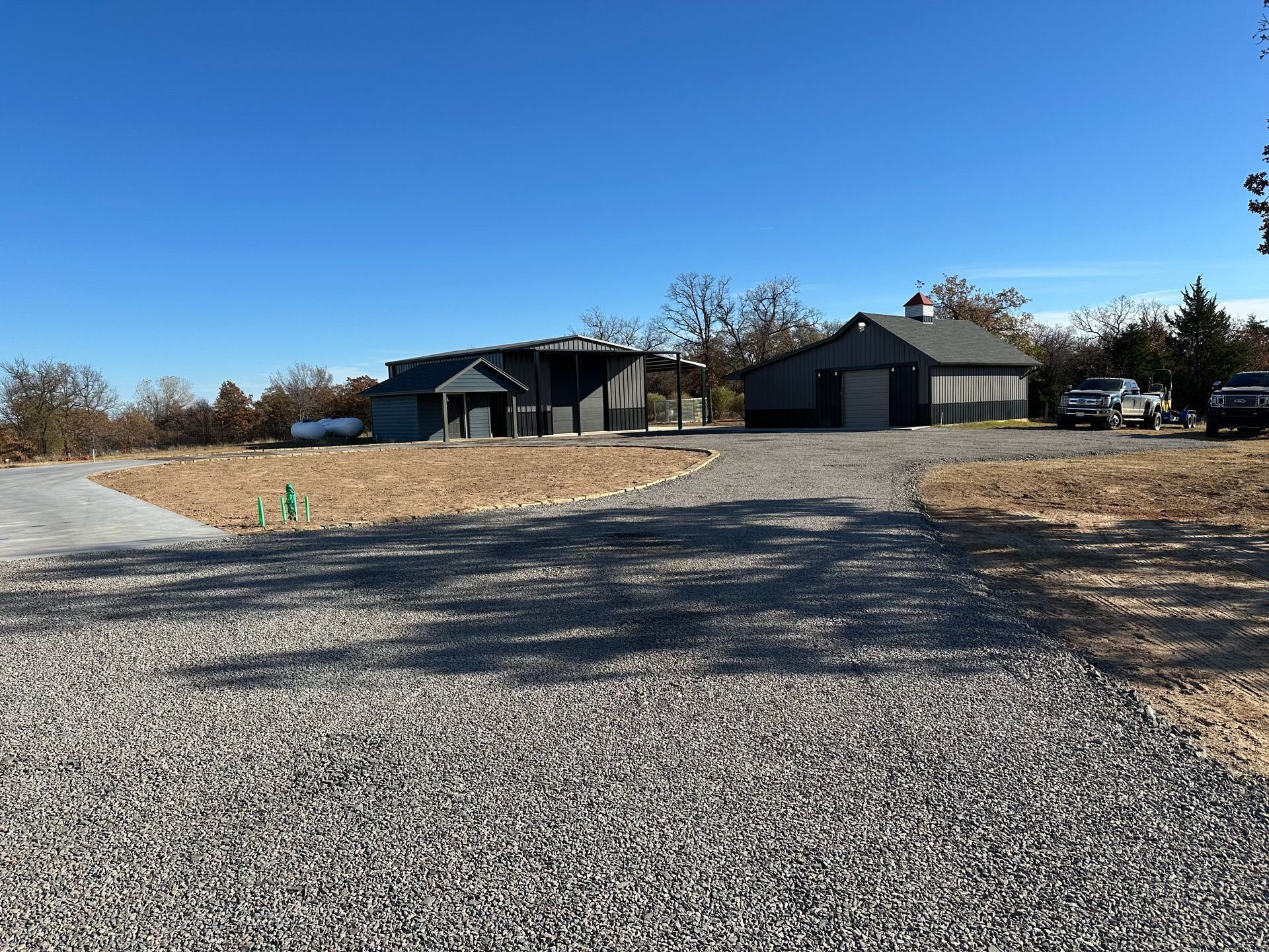 A gravel driveway leading to a house and garage