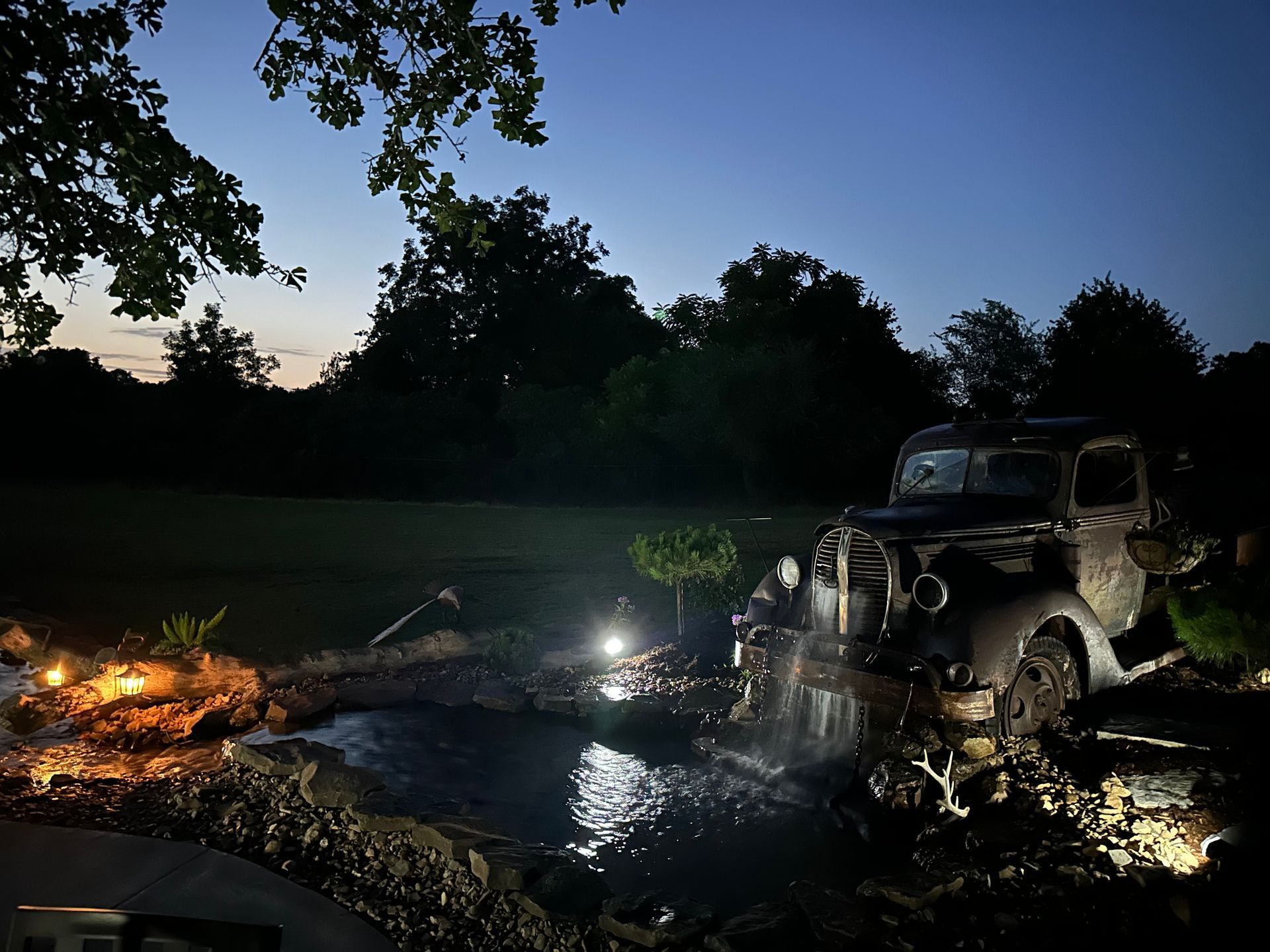 A car is parked next to a body of water at night.