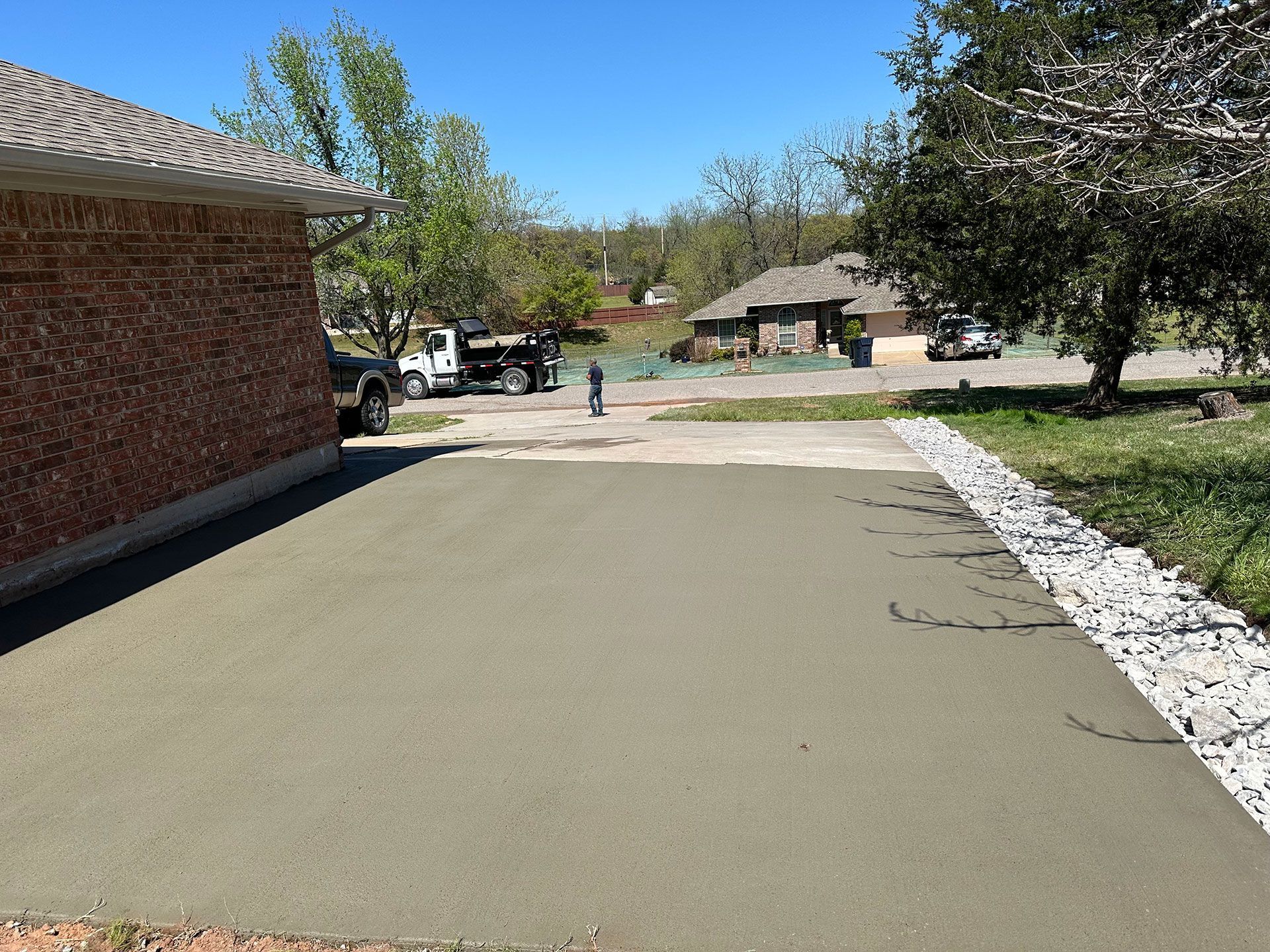 a concrete driveway is being built in front of a brick house
