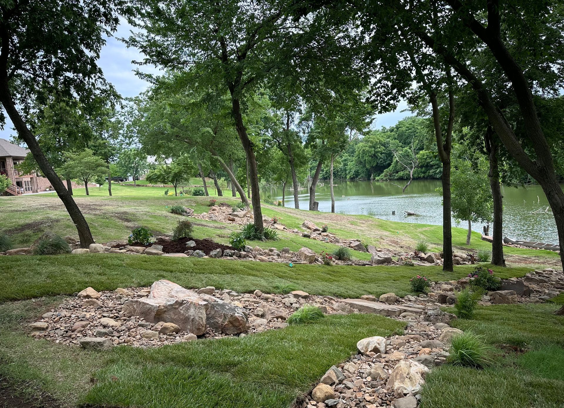A path leading to a lake surrounded by trees and rocks.