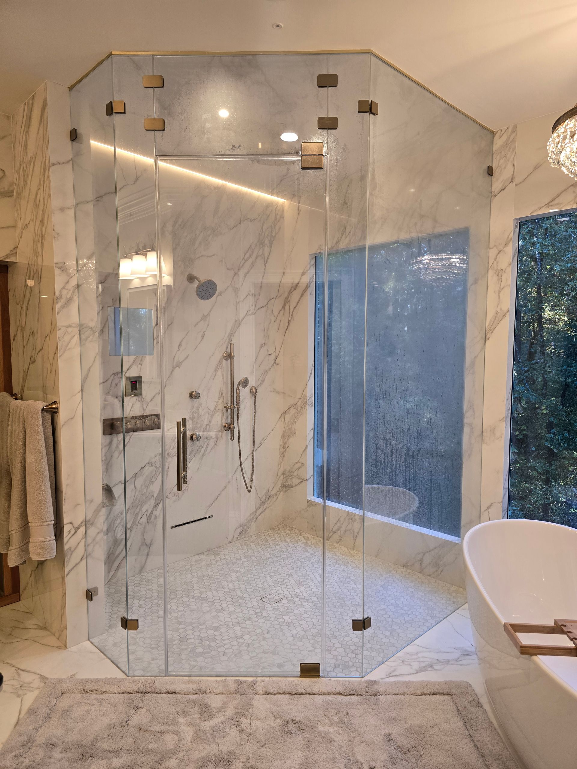 Luxury bathroom with a multi-pane glass shower and marble walls