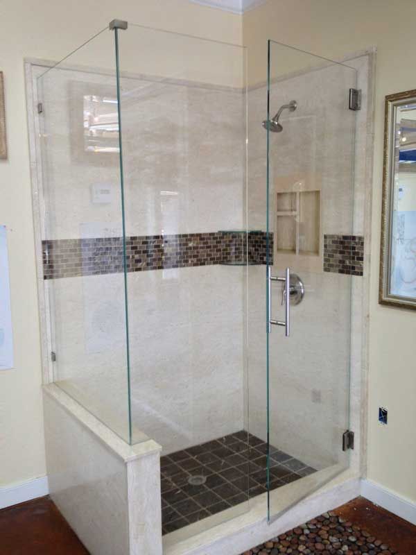 A bathroom with a walk in shower with a glass door
