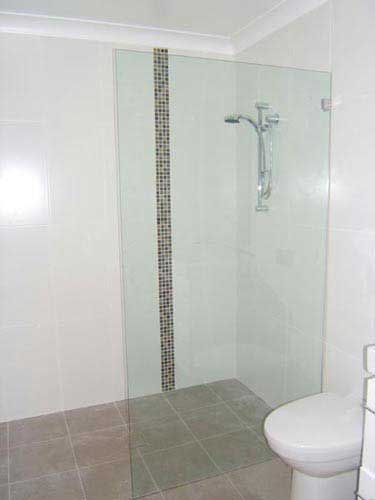 A bathroom with a walk in shower and a toilet.