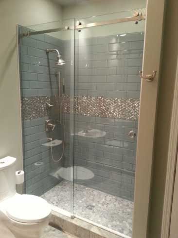 A bathroom with a toilet and a shower with a sliding glass door.