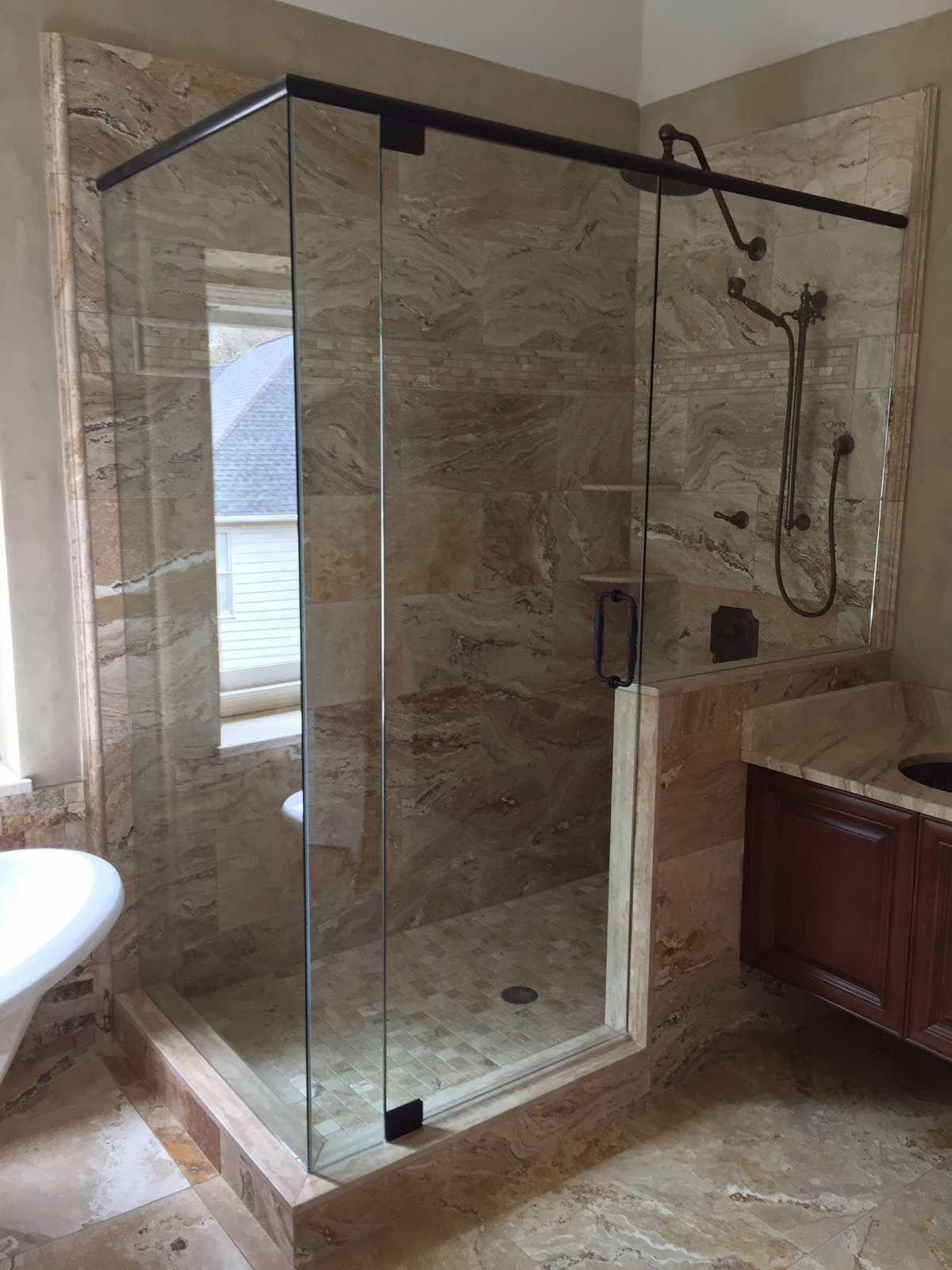 A bathroom with a walk in shower and a sink.