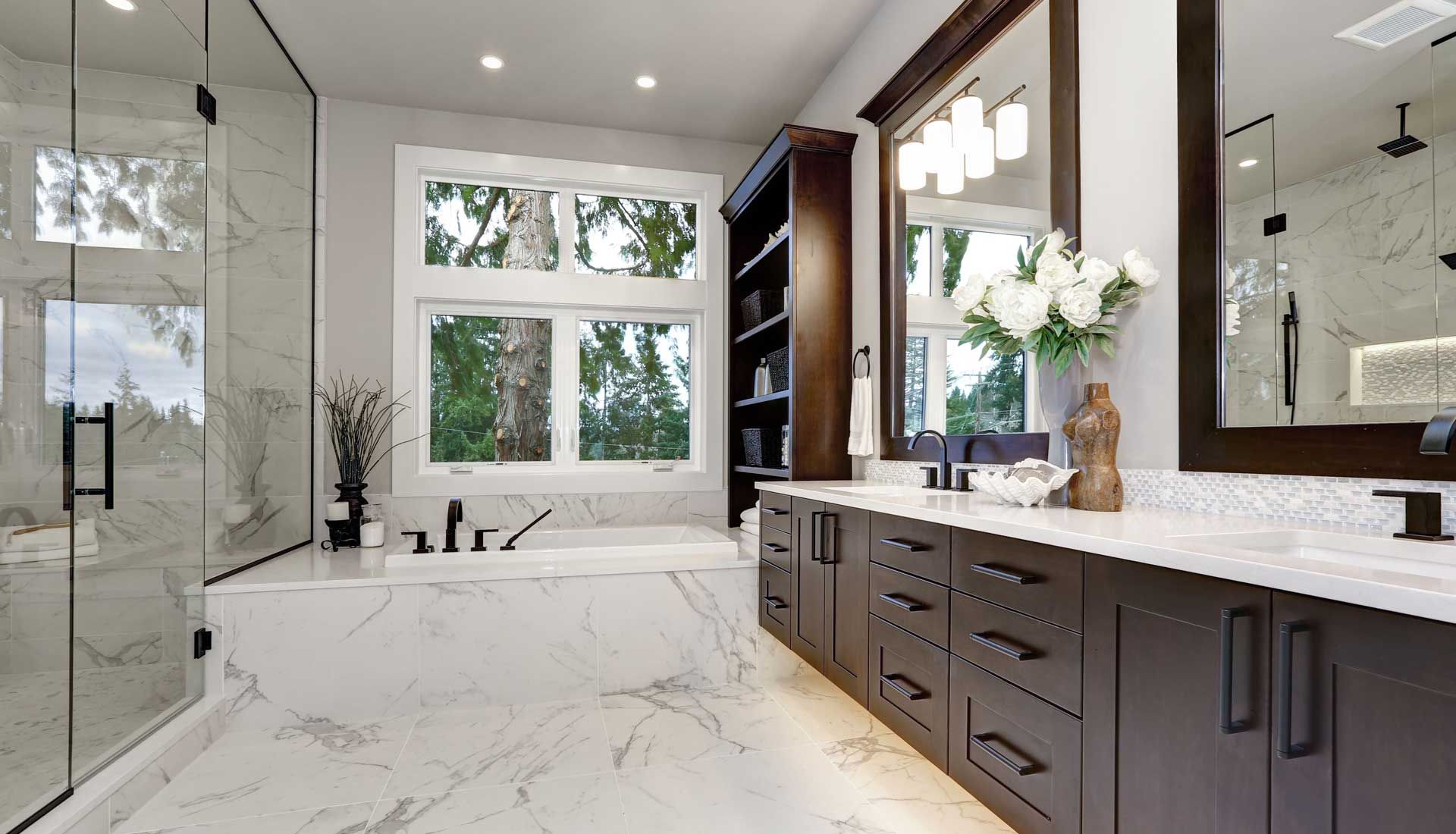 A bathroom with two sinks , a tub , and a large mirror.