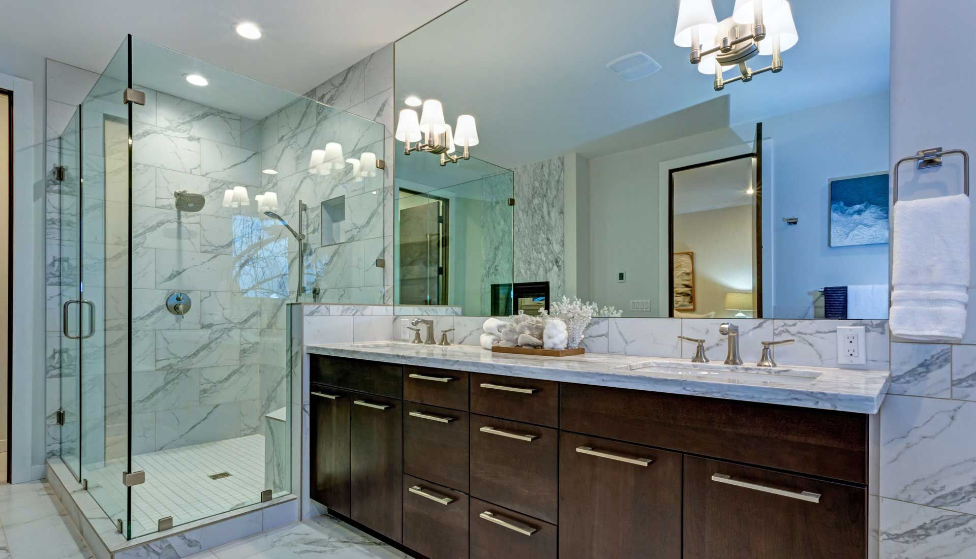 A bathroom with two sinks , a walk in shower and a large mirror.