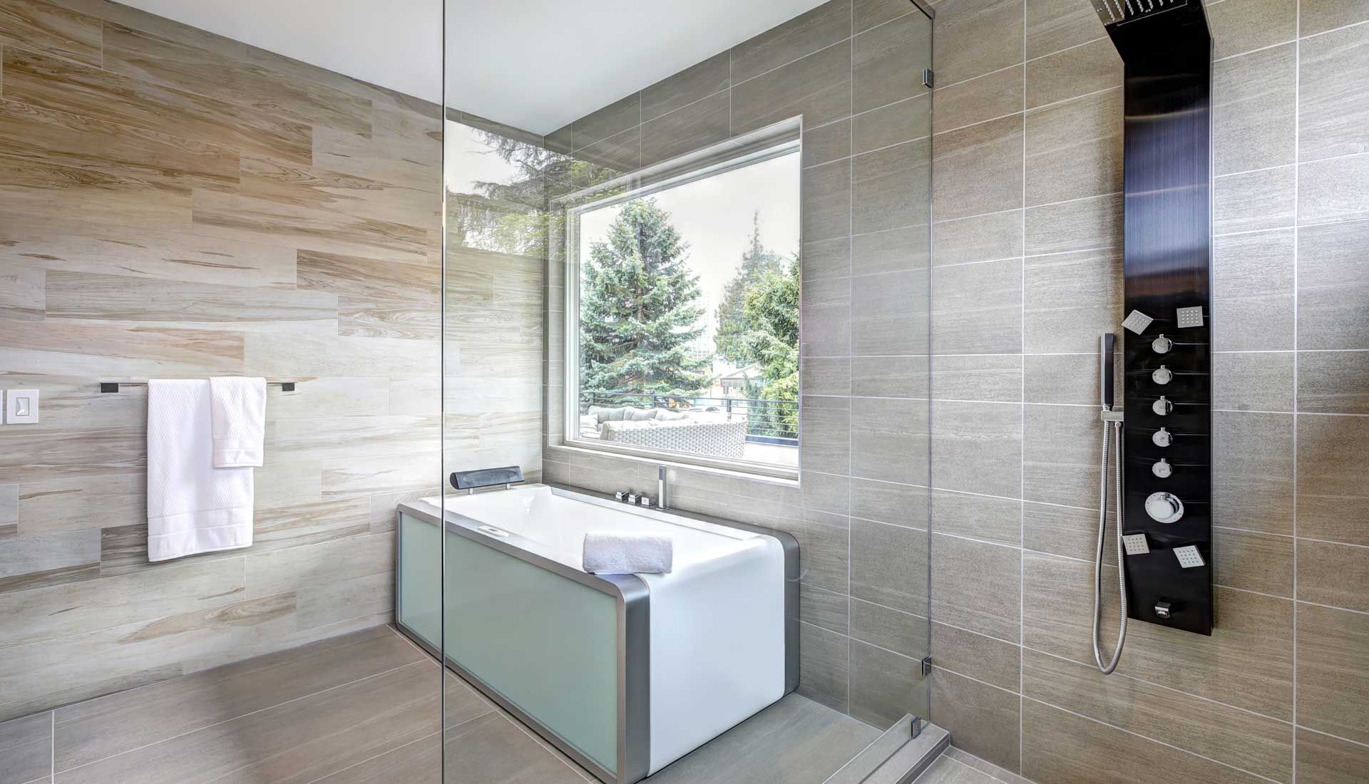 A bathroom with a bathtub , shower , and window.