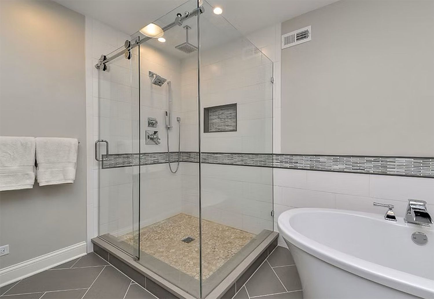 A bathroom with a walk in shower and a bathtub.