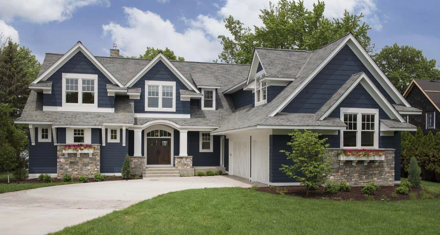A large blue house with a gray roof and white trim