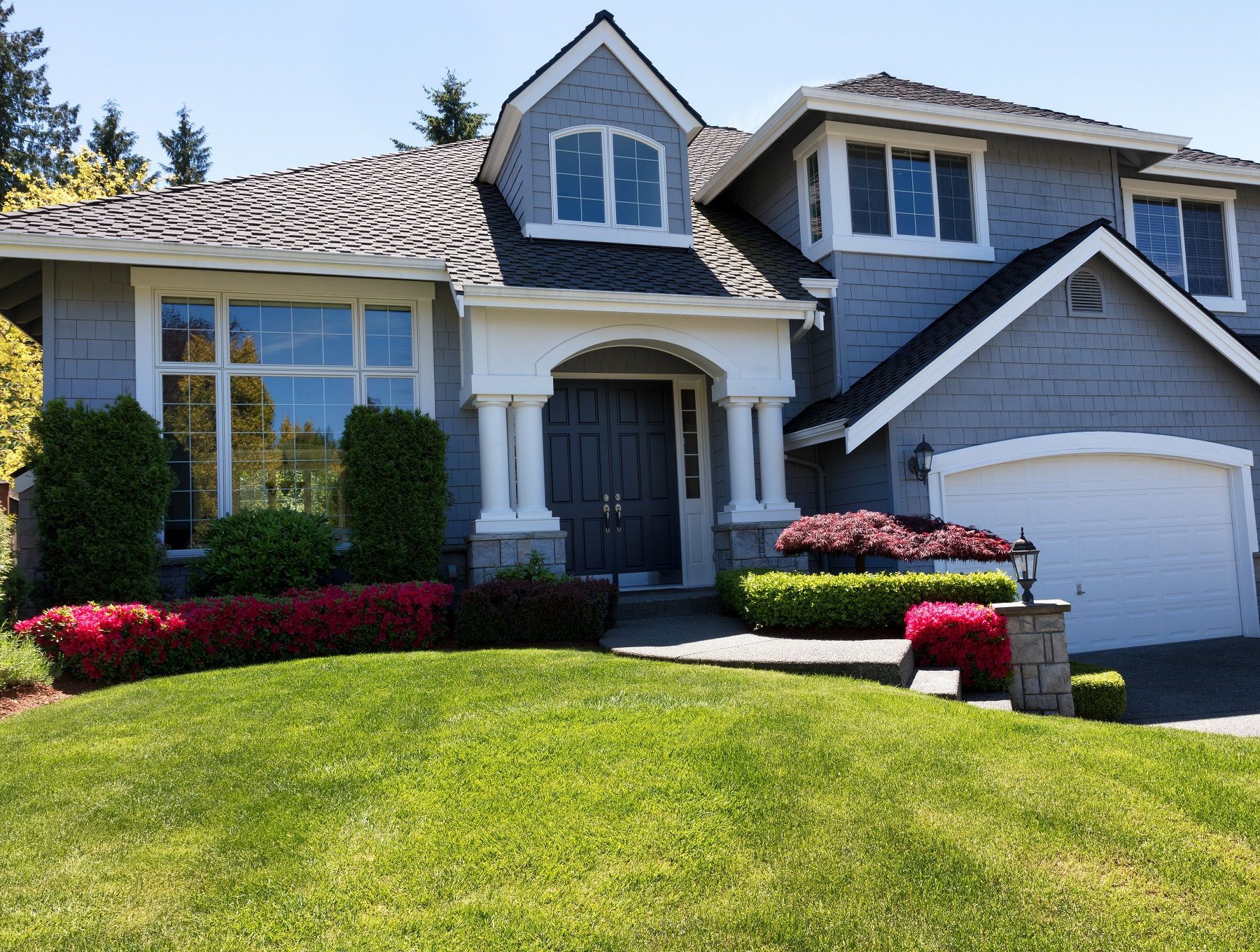 A large house with a lush green lawn in front of it