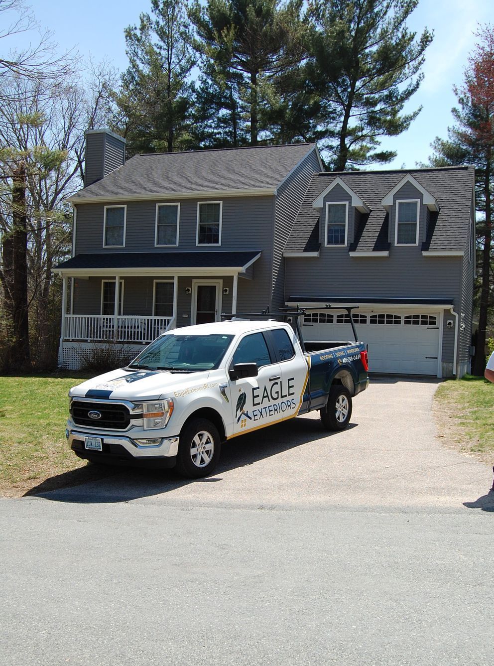 A white truck is parked in front of a house.