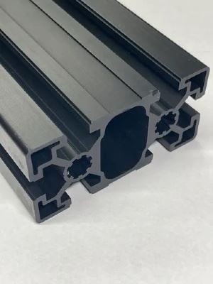 A close up of a black aluminum extrusion on a white surface.