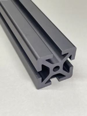 A close up of a black aluminum extrusion on a white surface.