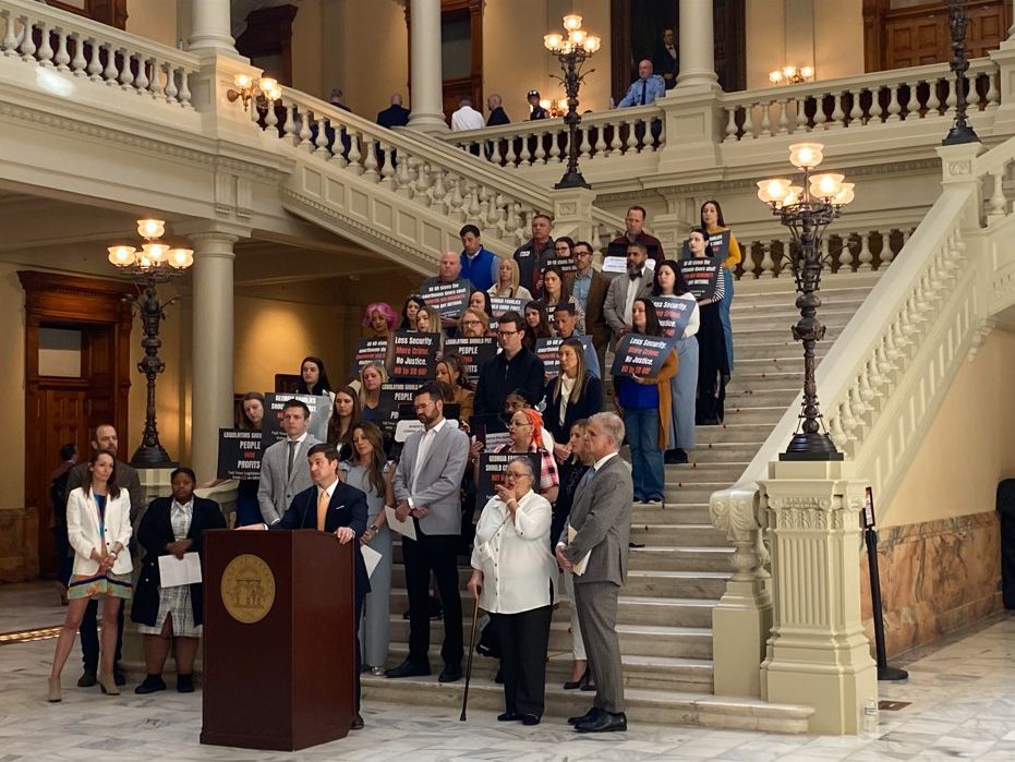 People are gathered on a staircase around a podium at its base.