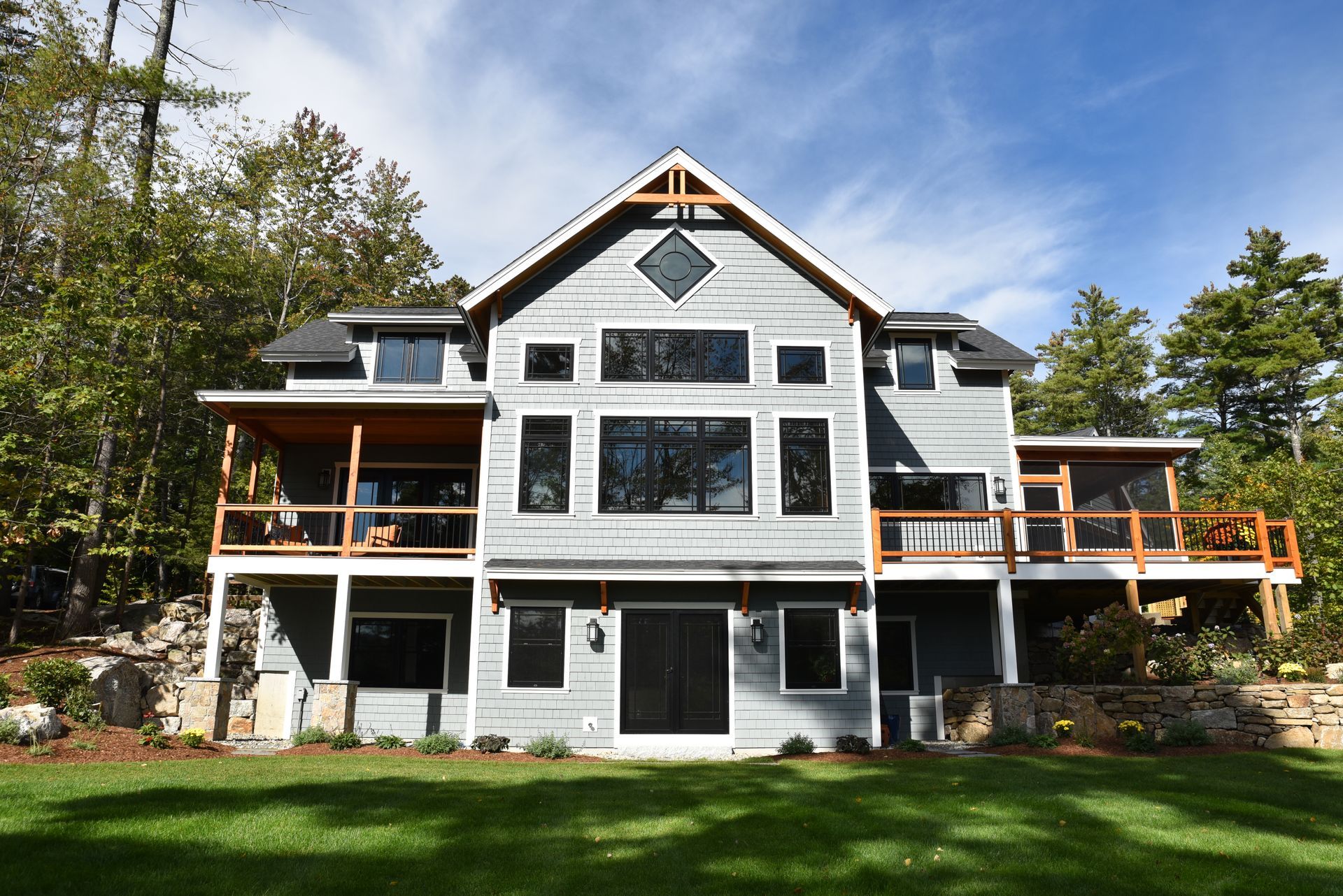 A large house with a lot of windows is surrounded by trees.