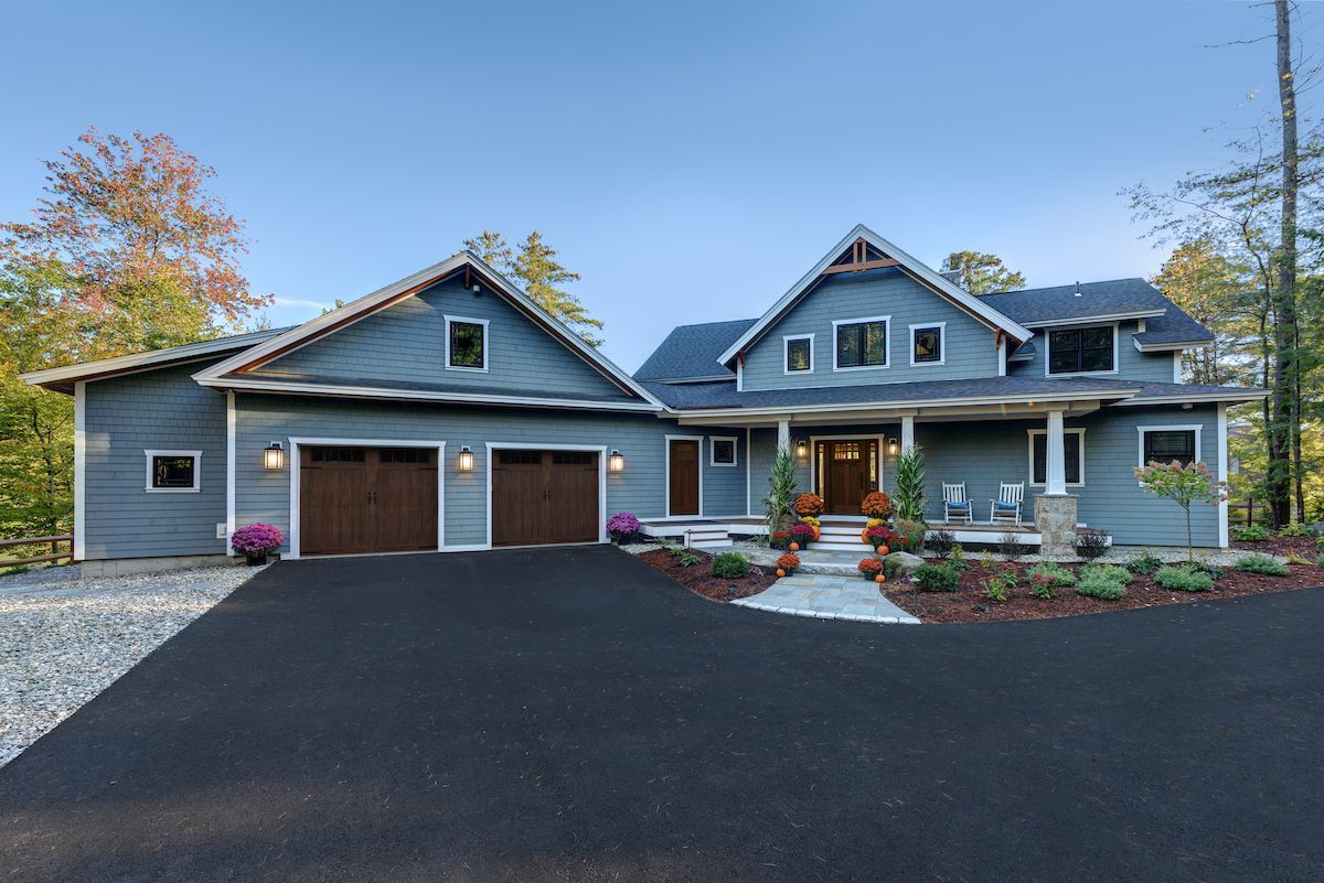 A large house with two garages is sitting on top of a hill.