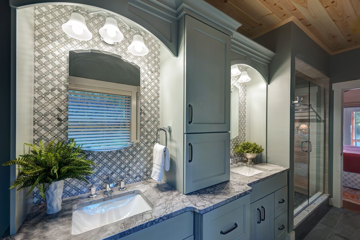 A bathroom with two sinks , a mirror and a window.