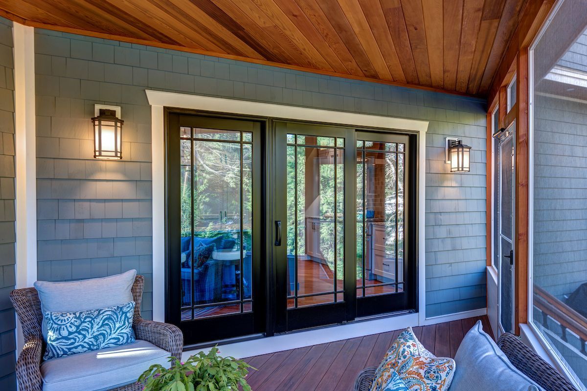 A screened in porch with sliding glass doors and a couch.