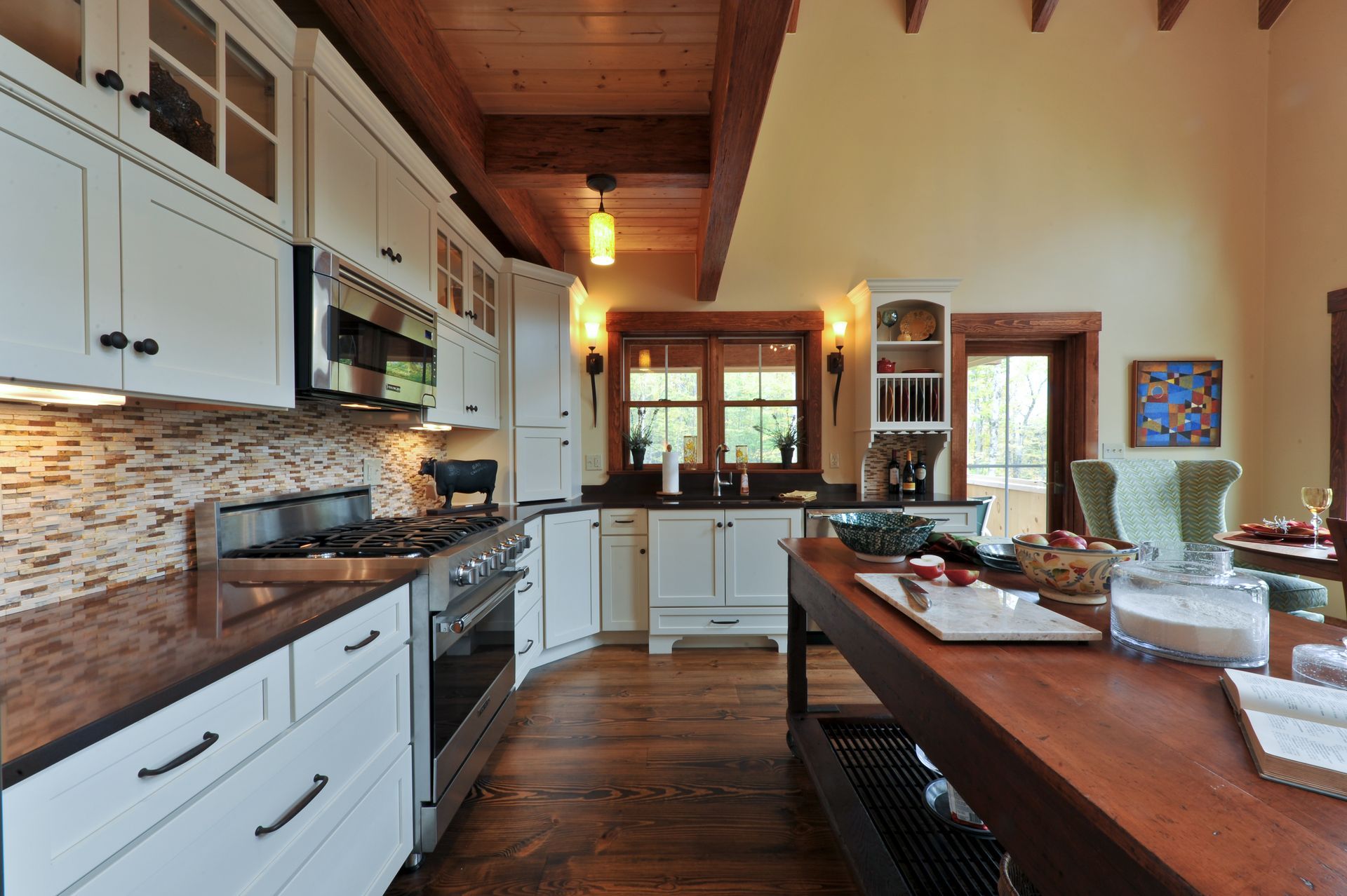 Kitchen with white cabinets, wood island, and stainless steel appliances.