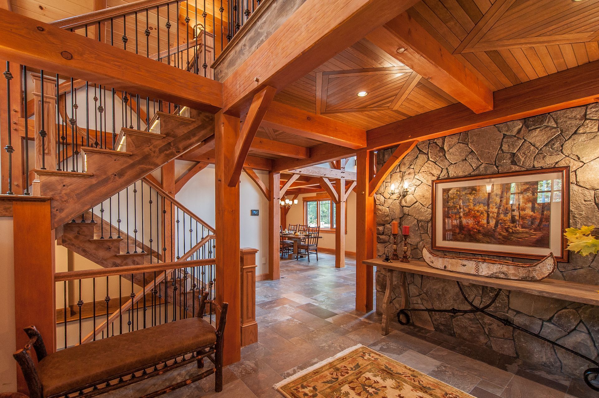 Wooden interior with staircase, stone wall, bench, and dining room visible.