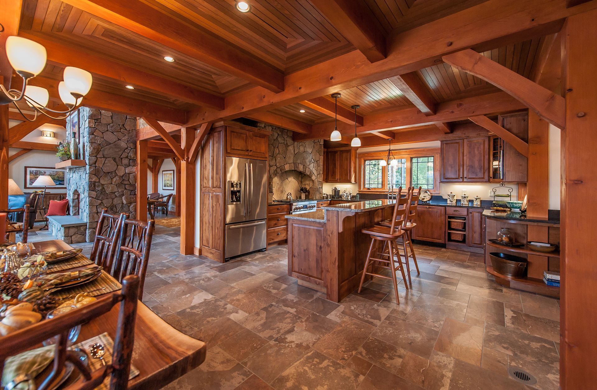 Rustic kitchen with wooden beams, stone accents, and brown cabinets.