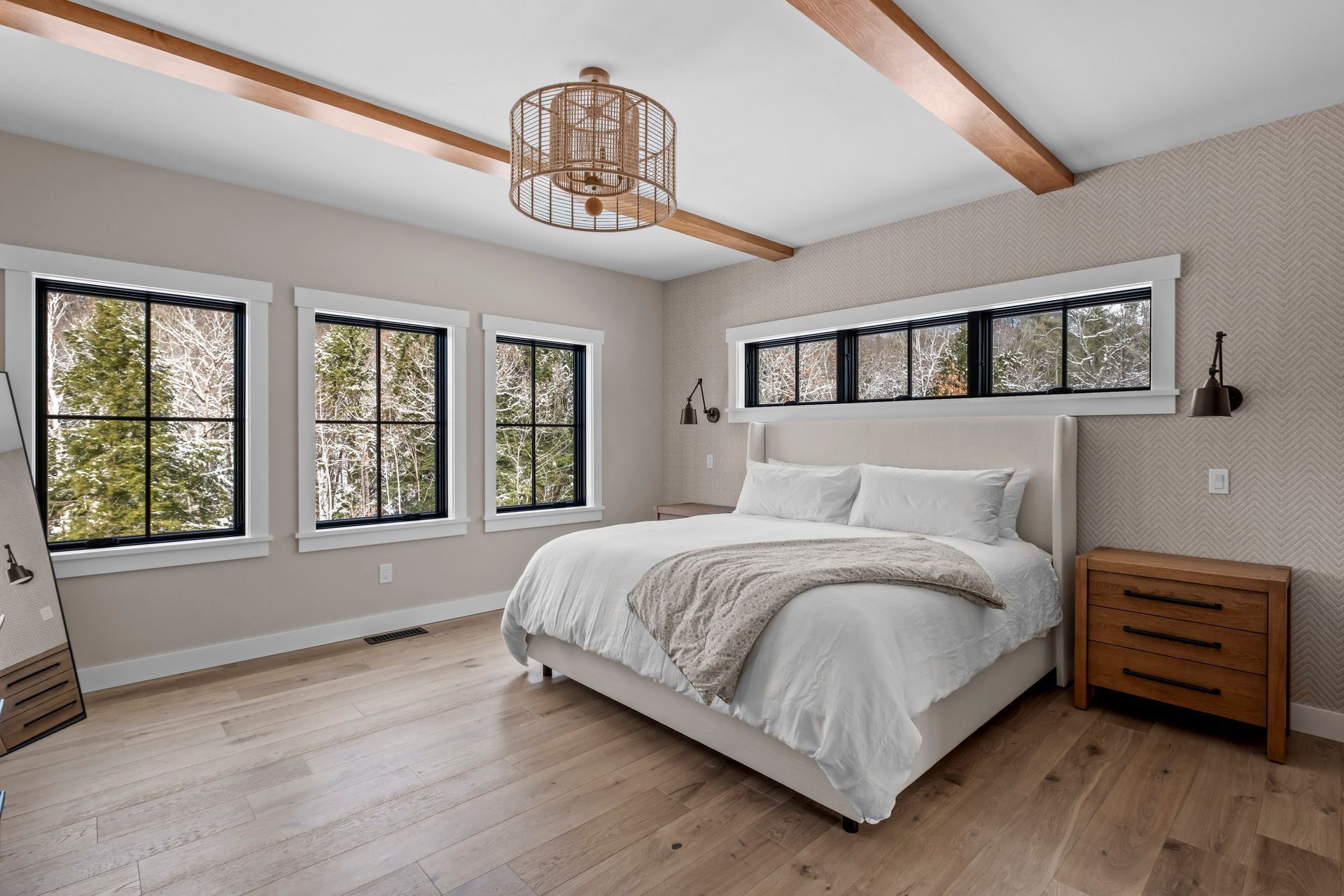 Bedroom with bed, windows, wooden beams, light fixture, and wooden dresser.