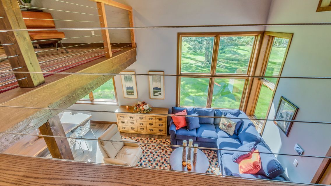 An aerial view of a living room with a blue couch and lots of windows.