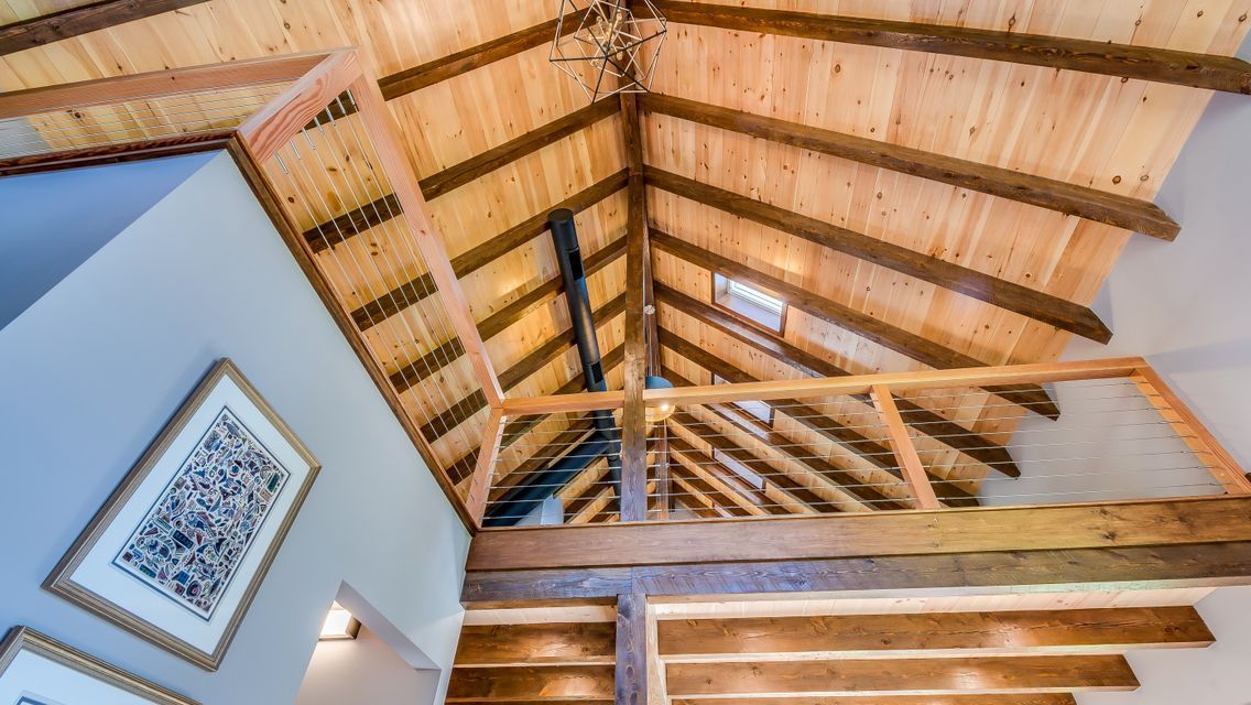 Looking up at the ceiling of a house with wooden beams.