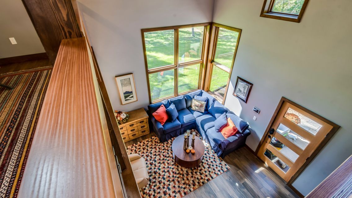 An aerial view of a living room with a blue couch and lots of windows.