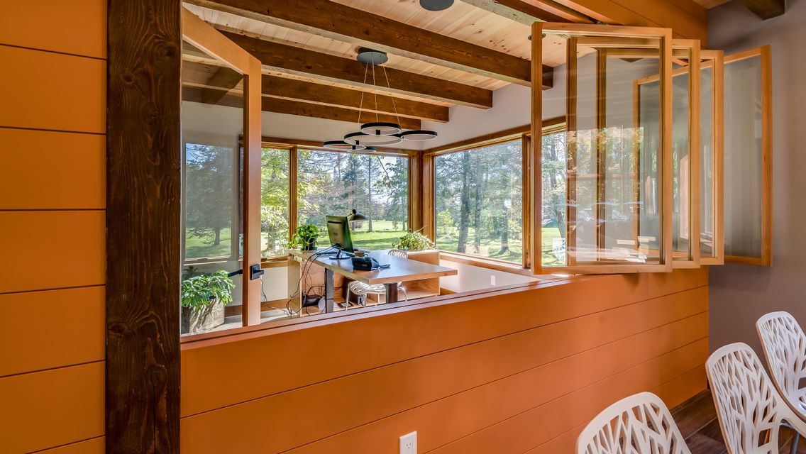 A room with a lot of windows and chairs in it.