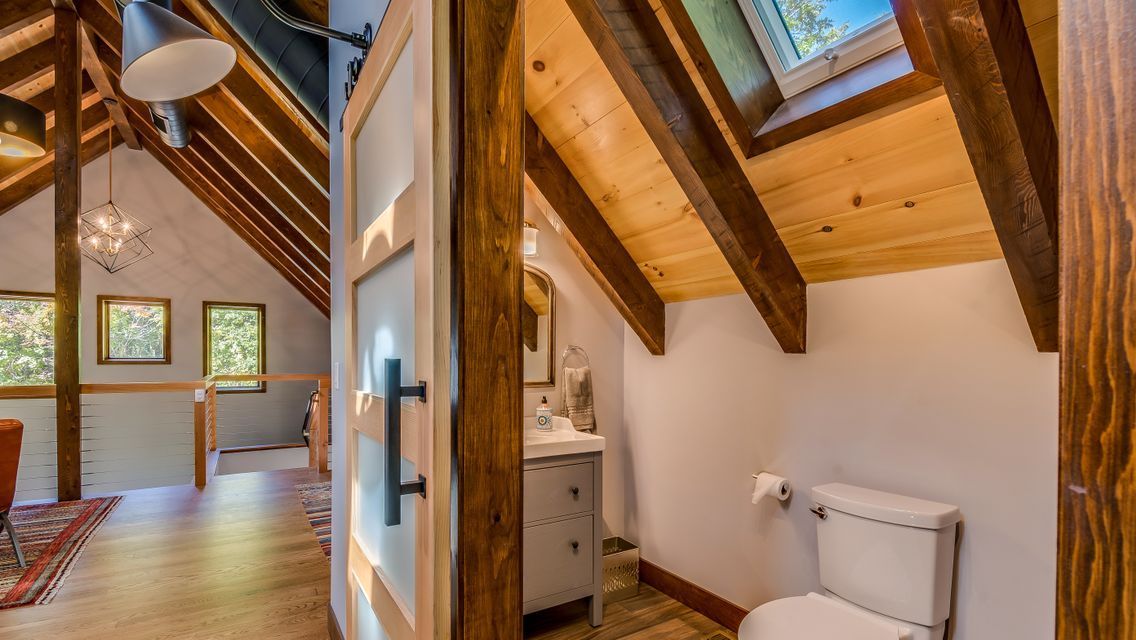 A bathroom with a toilet , sink , and window.