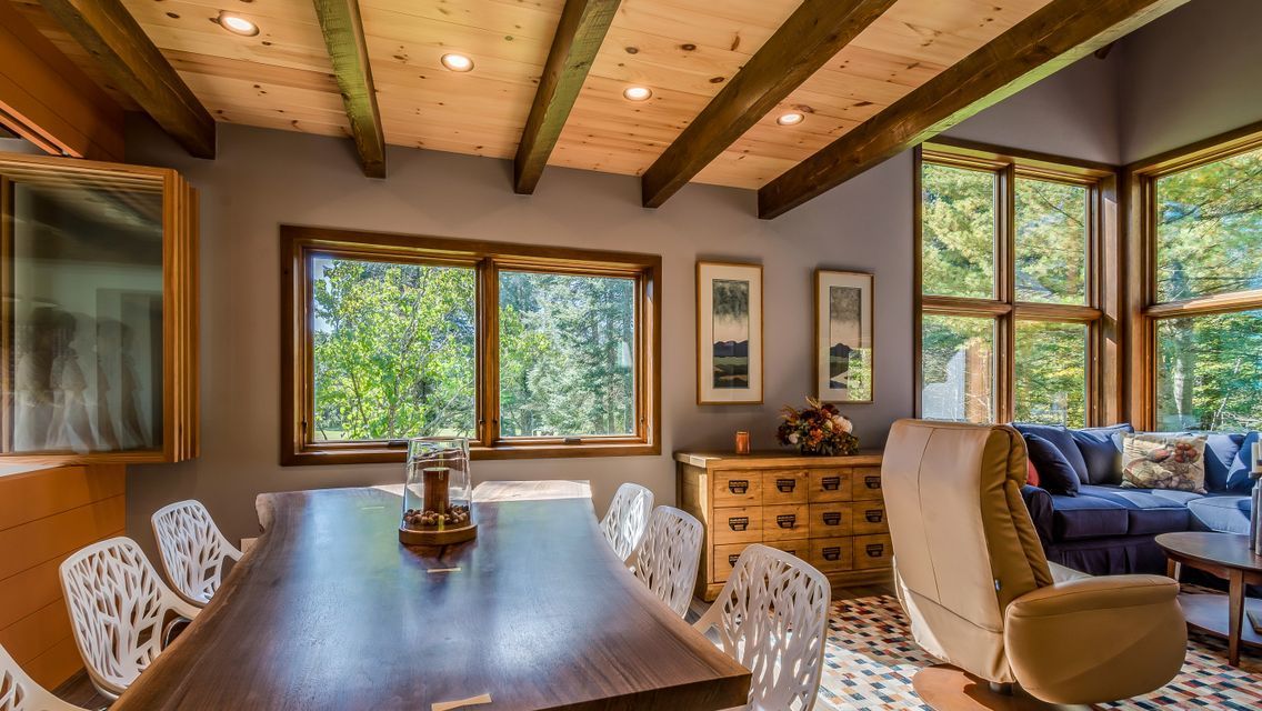 A living room with a table and chairs and a couch.