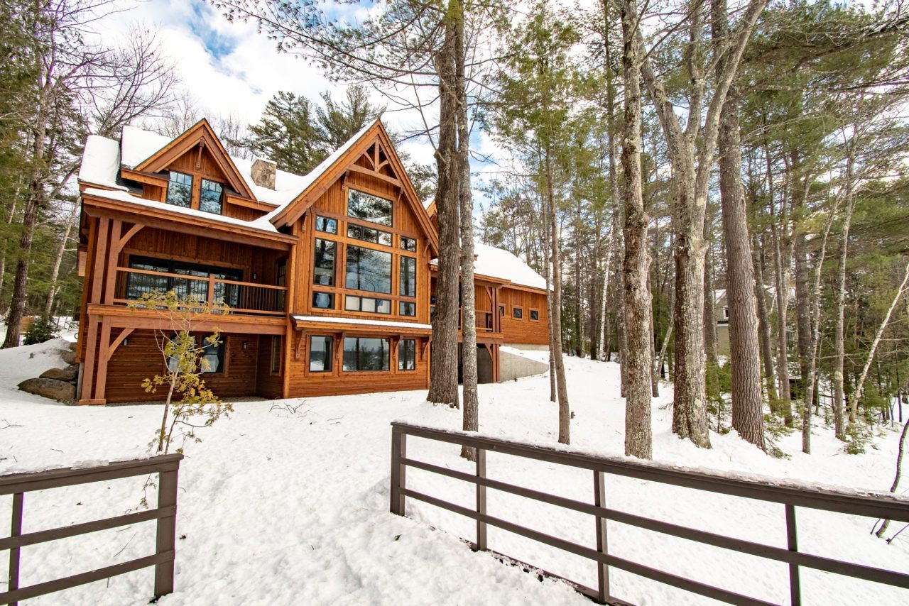 A large wooden house in the middle of a snowy forest.