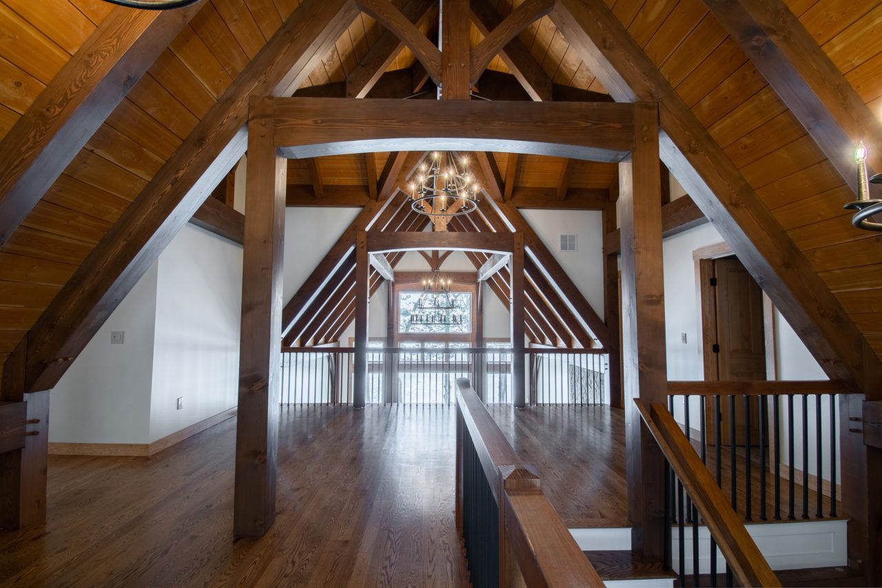 An empty attic with wooden beams and stairs