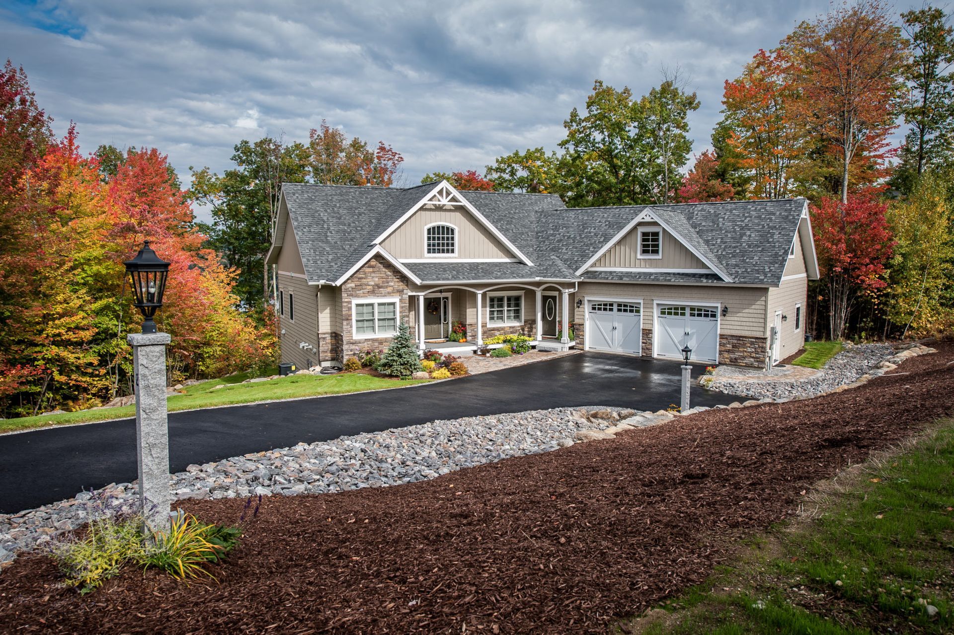 A large house with a driveway and trees in the background.
