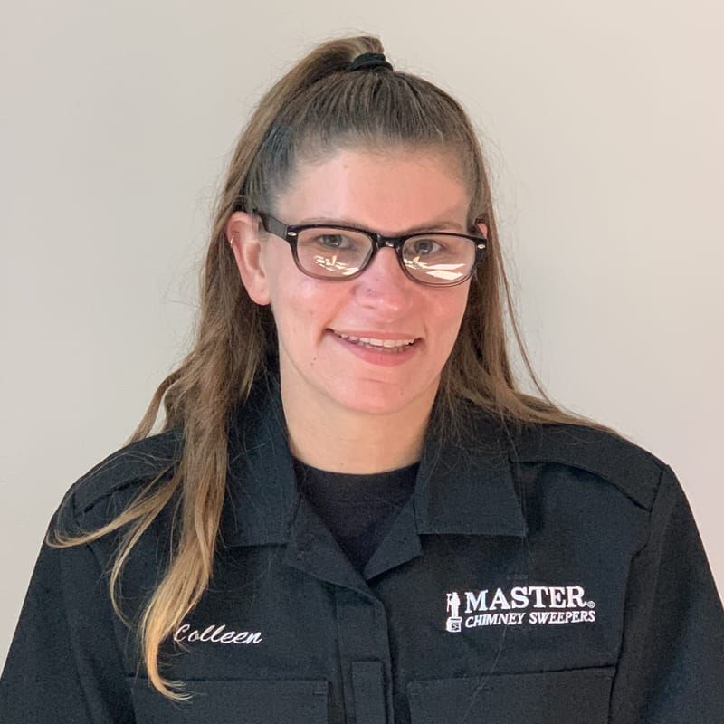 A woman wearing glasses and a black shirt is smiling for the camera.