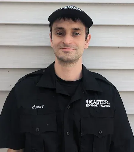 A man with a mustache is wearing a hat and a black shirt.