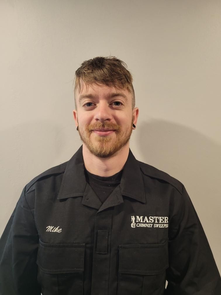 A man with a beard is wearing a black shirt with the word master on it.