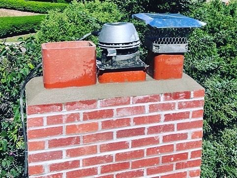 A brick chimney with two chimneys on top of it