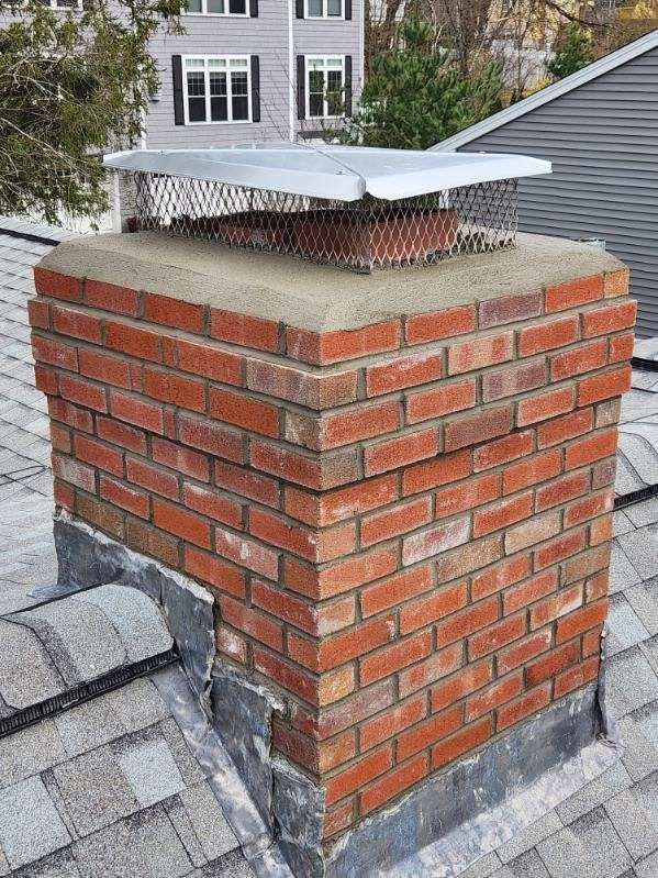 A brick chimney is sitting on top of a roof